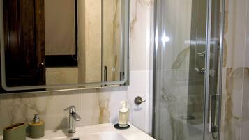Suite junior, vistas a la ciudad | Baño | Ducha, toallas, jabón y champú