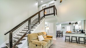 A modern interior with a wooden staircase, a beige sofa, and a kitchen area. - 4 Mi to Lake Barkley: Pet-friendly Home w/ Hot Tub (Cadiz)