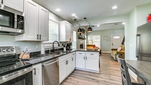 A modern kitchen with white cabinets, stainless steel appliances, and a central island. - 4 Mi to Lake Barkley: Pet-friendly Home w/ Hot Tub (Cadiz)