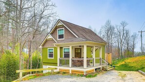 A small, single-story house with a porch and a front door. - On Farm: Charming Hendersonville Retreat! (Hendersonville)
