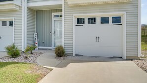 A modern two-story house with a garage, a welcome sign, and a small garden area. - Patio & Grill: Modern Family Home in Hampstead (Hampstead)