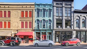 A row of historic buildings with storefronts, including a pawn shop and a jewelry store. - Steps to Historic Riverfront: Chic Dtwn Condo! (Paducah)