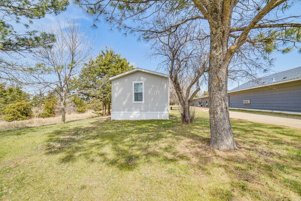 A small, single-story house with a front yard, surrounded by trees and a clear sky. - Dog-friendly Miller Hunting Retreat! (Miller)
