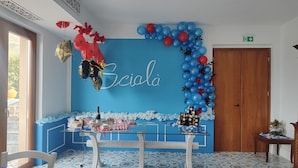 Ein Zimmer mit blauer Wand, einem Tisch mit Glasplatte und einer Tür.