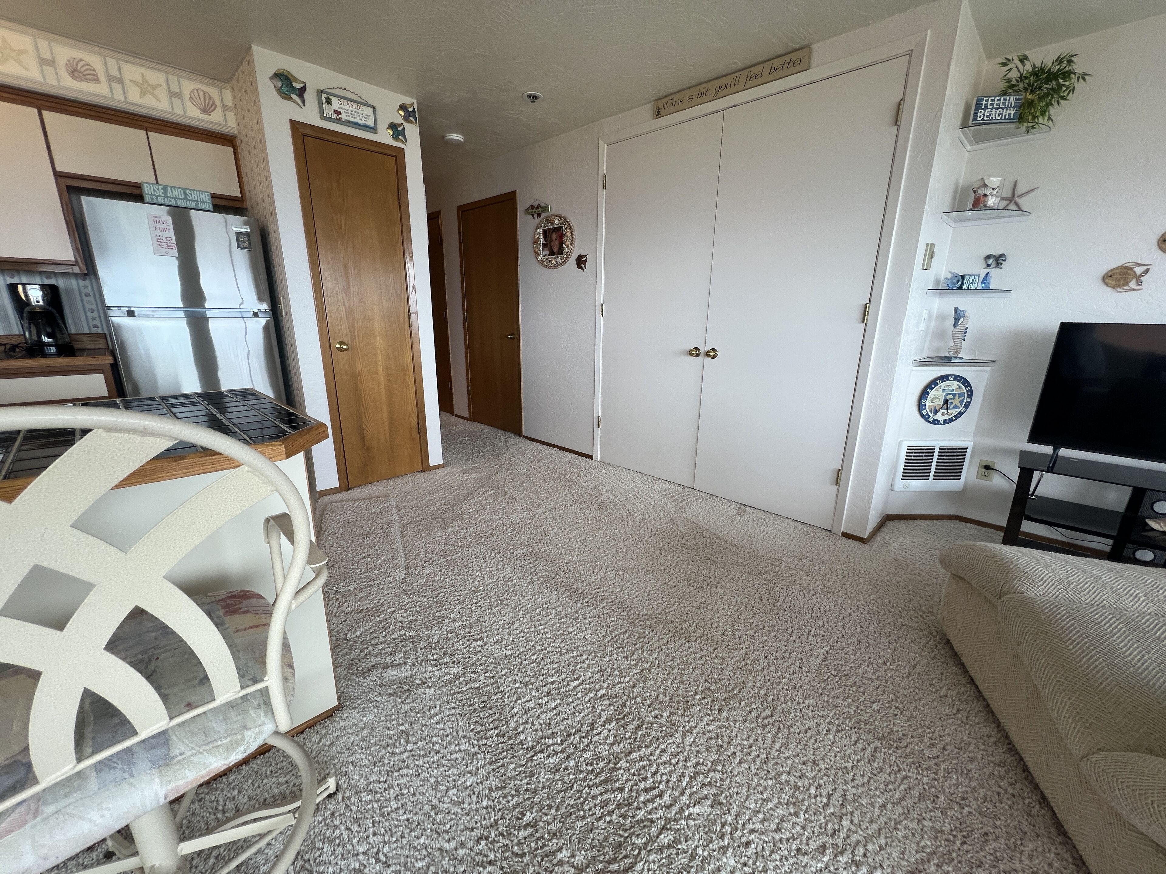 A compact living space with a kitchenette, a dining area, and a TV.