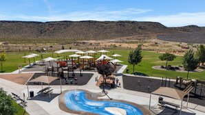 A playground with slides and swings, a pool with a wave feature, and picnic tables. - Lakeside Oasis at Sand Hollow: Private Pool + Private Hot Tub (Hurricane)