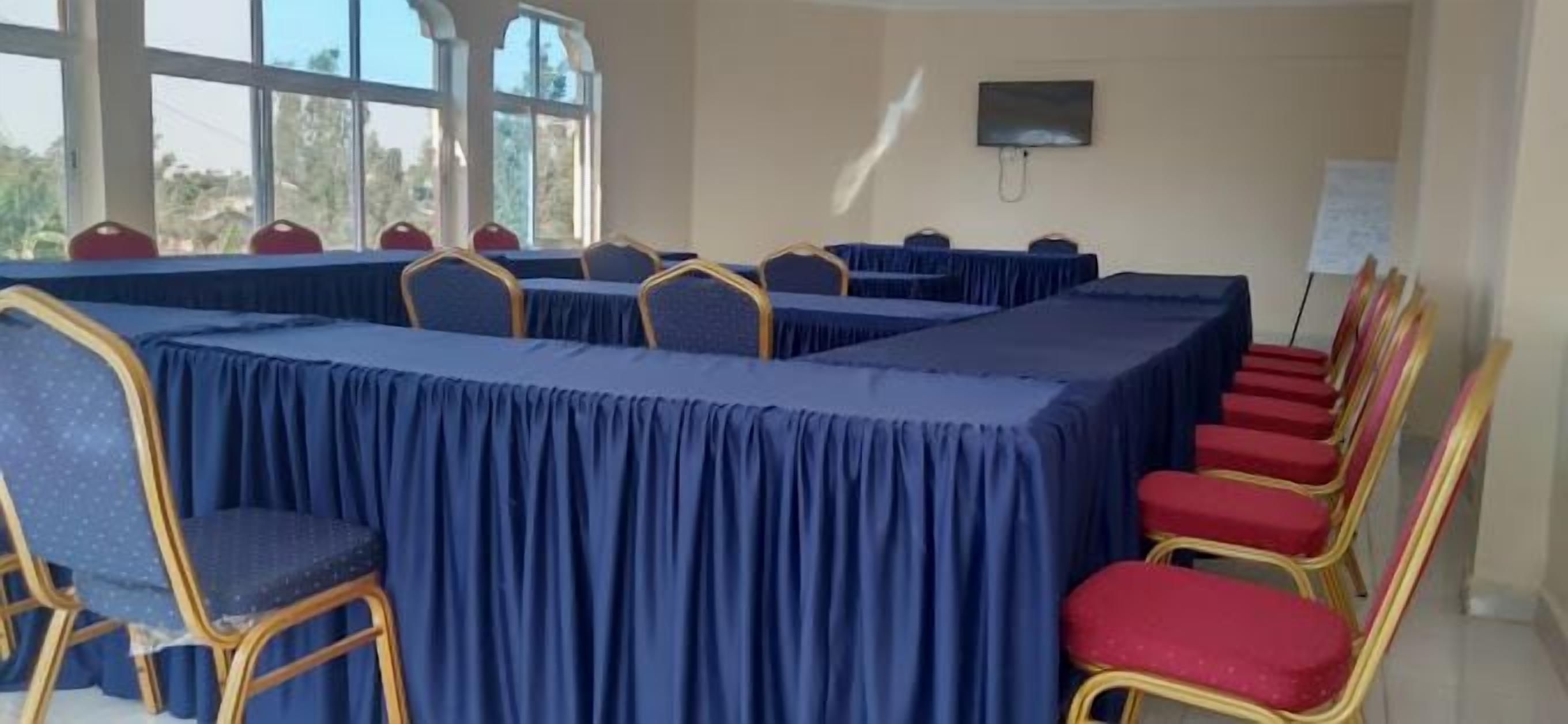 A conference room with a long table, chairs, and a whiteboard.