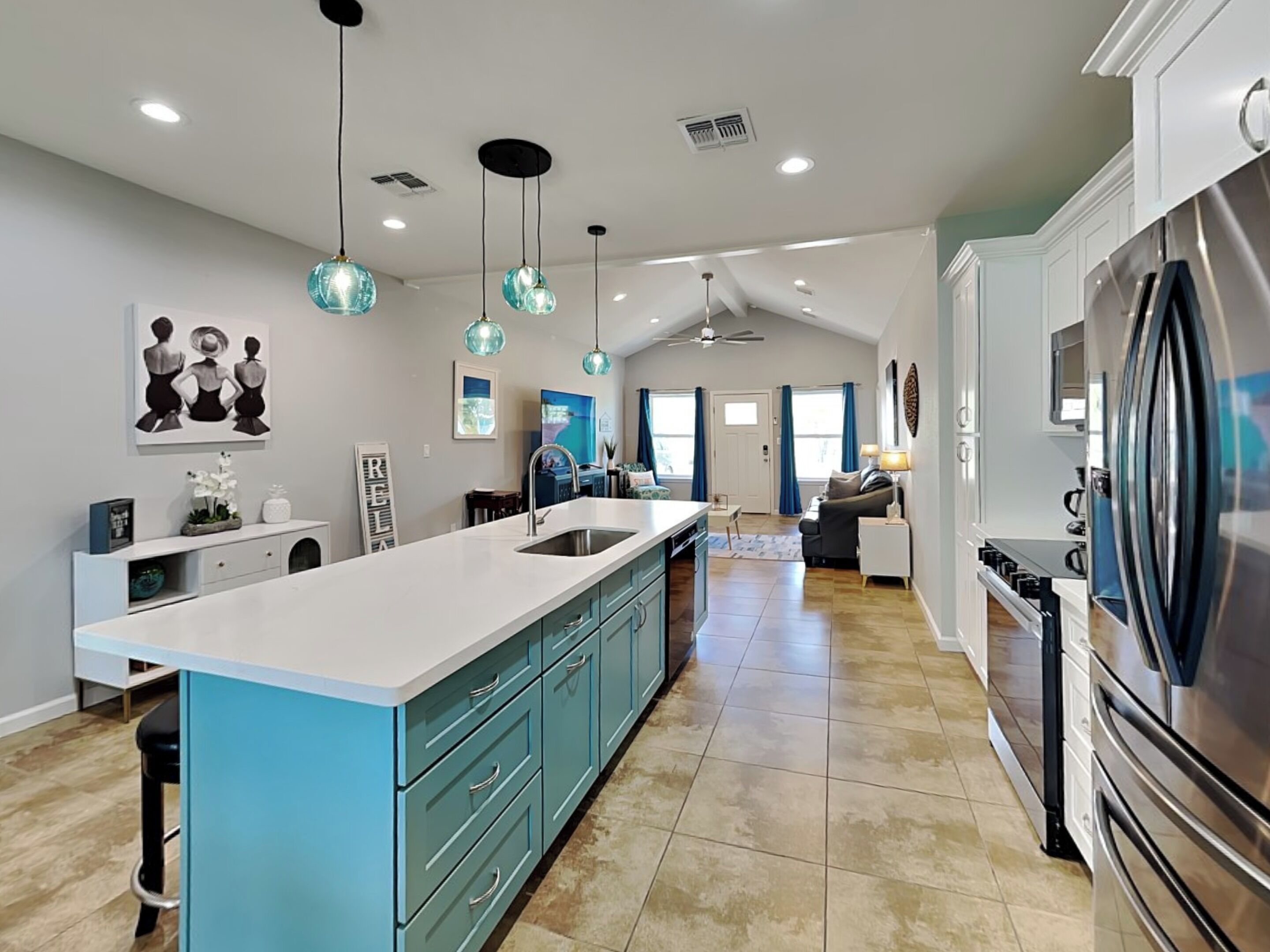 A spacious kitchen with a large island, modern appliances, and pendant lighting.