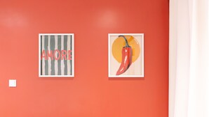 Two framed artworks on a red wall.