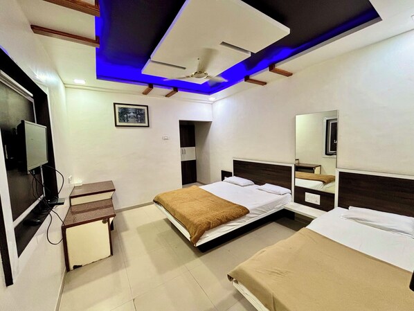 Un dormitorio moderno con una cama, mesitas de noche, un televisor y una lámpara en el techo.