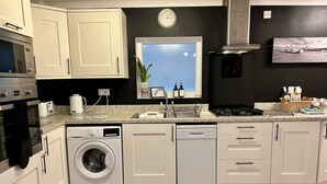 A modern kitchen with a built-in washer and dishwasher, a microwave, and a stove.