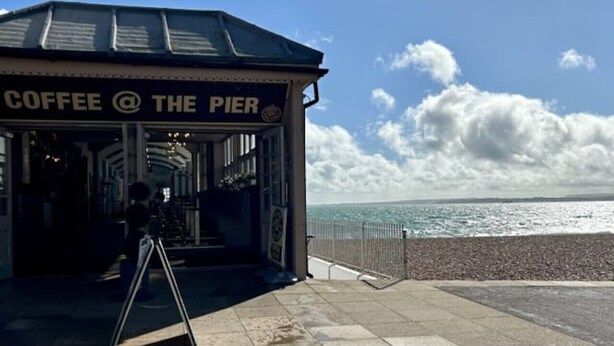 A coffee shop named "Coffee @ The Pier" with a view of the sea.