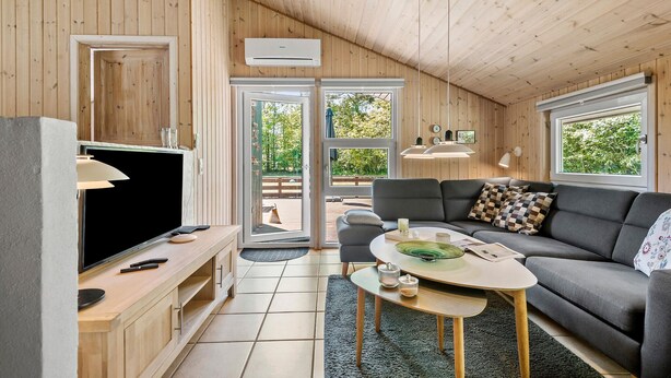 A modern living room with a large flat-screen TV, a grey sofa, and a coffee table. - Stunning home in Oksbøl with sauna (Oksbøl)
