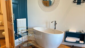 A modern bathroom with a freestanding bathtub, a glass-walled shower, and a towel rack. - No. 1 High Street - Boutique Rooms (Markinch)