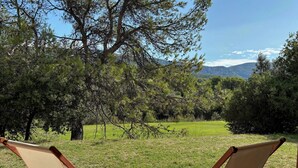 Two canvas folding chairs facing a grassy area with trees and a distant mountain range. - (New) Superb apartment in Golf (Saumane-de-Vaucluse)