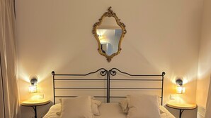A neatly made bed with a headboard, two bedside lamps, and a mirror on the wall. - (New) Superb apartment in Golf (Saumane-de-Vaucluse)