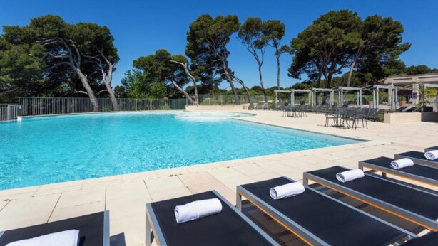 A swimming pool with lounge chairs and a pergola, surrounded by trees. - (New) Superb apartment in Golf (Saumane-de-Vaucluse)