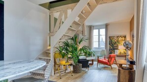 Un saló modern amb una escala, una zona de menjador i un espai d'estar.
