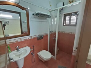 Een douche, handdoeken, zeep, shampoo