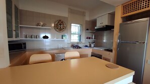 A modern kitchen with a central island, built-in appliances, and a dining area.