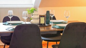 Une table à manger dressée avec des assiettes, des verres et une bougie.