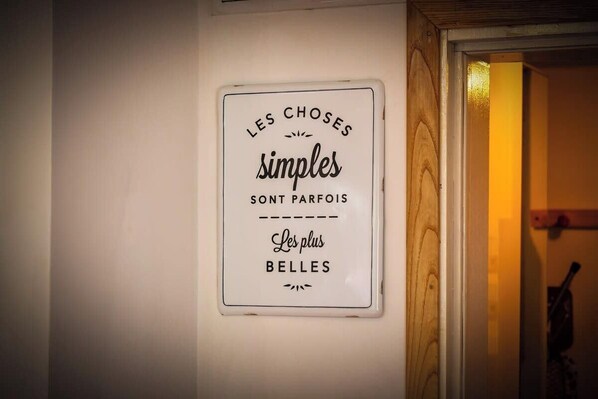 Un cartel en una pared con el texto 'LES CHOSES simples sont parfois les plus belles'.