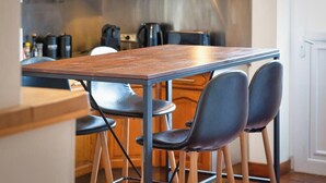 Een moderne keuken met een houten tafel en zwarte stoelen.