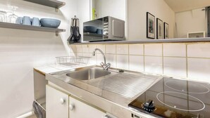 Et moderne køkken med rustfrie stålapparater, en dobbeltvask og en indbygget mikrobølgeovn.
