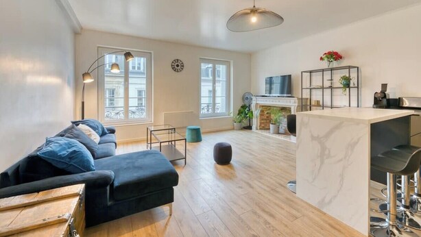 Un appartement moderne comprenant un salon, une cuisine et un coin repas.