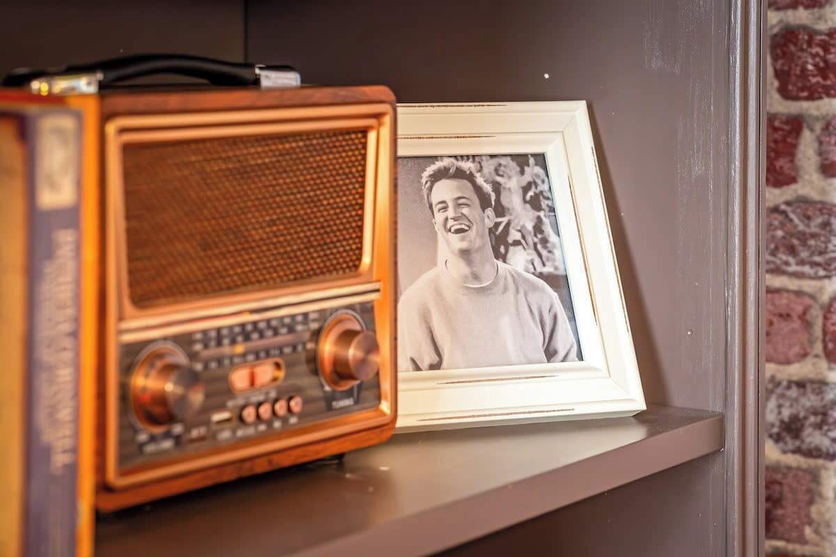 Une vieille radio et une photographie encadrée, posées sur une étagère.