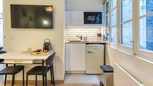Kompakti keittiö, jossa on taulutelevisio, mikroaaltouuni ja astianpesukone.