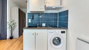 A compact kitchen with a washing machine, a sink, and cabinets. - Rollin, appartement 3 personnes avec Netflix au calme ! (Sotteville-lès-Rouen)