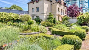 Un immeuble de deux étages avec un jardin à l’avant.