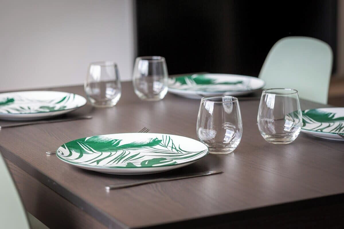 A dining table with plates and glasses.