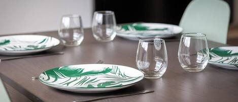 A dining table with plates and glasses.
