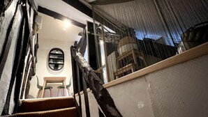 A staircase with a wooden handrail and a chair at the bottom. - Vera : Studio Confortable sous les combles ! (Rouen)