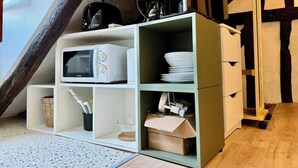 A compact kitchen with a microwave, a coffee maker, and a Wi-Fi router on a shelf. - Vera : Studio Confortable sous les combles ! (Rouen)