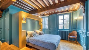 Une chambre à coucher avec un lit, un plancher en bois et une fenêtre.