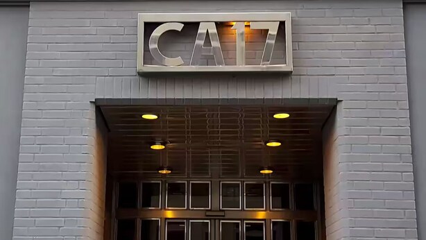 Entrada de un edificio con un letrero de metal que dice "CAI".