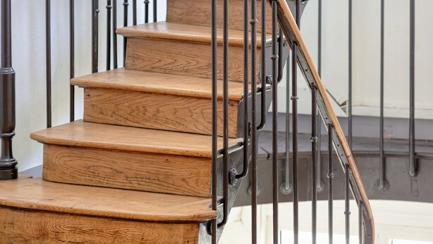 Eine Holztreppe mit Metallgeländern.