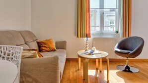 Ein modernes Wohnzimmer mit einer Couch, einem runden Tisch und einem Sessel.