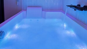 Een bad met douchekop en bedieningspaneel.