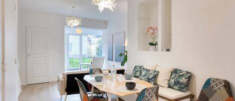 Un comedor moderno con una mesa de madera, sillas coloridas y un sofá blanco.