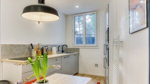 Una cocina moderna con un ventanal grande, una mesa de comedor y una planta en maceta.
