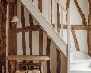 Un escalier avec des poutres en bois apparentes et une rampe blanche.