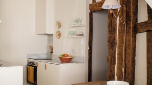 Une cuisine avec une table en bois, un saladier blanc et une lampe suspendue.