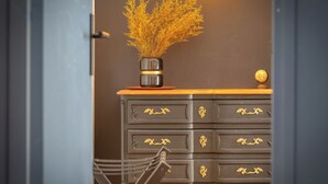 A dark wooden dresser with gold handles and a vase of dried flowers on top. - L'escale du Gros-Horloge, une parenthèse prestigieuse au coeur de Rouen (Rouen)