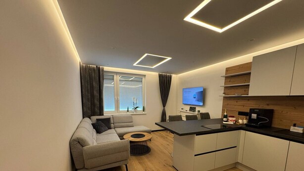 Un appartement moderne comprenant un espace de vie, une cuisine et un coin repas.