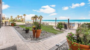 A patio area with a view of the ocean, potted plants, and a pathway leading to the beach. - Oceanside Inn Studios by Brightwild (Daytona Beach Shores)