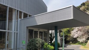 A building with a covered entrance, large windows, and a statue of an elephant. - kogikusou (Kikugawa)